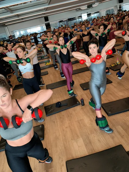 Aula Wolffit lotada, alunas com caneleira no mesmo movimento