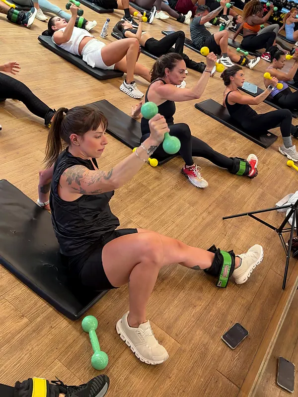Professora com halter e caneleira no treino prático da Certificação