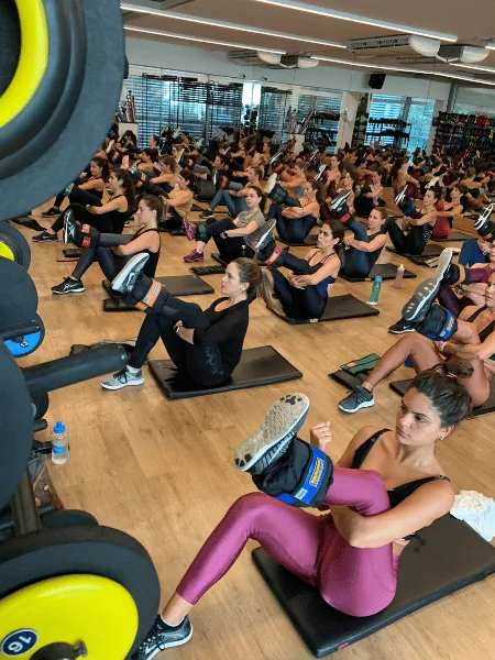 Sala cheia numa aula Wolffit, alunas no colchonete